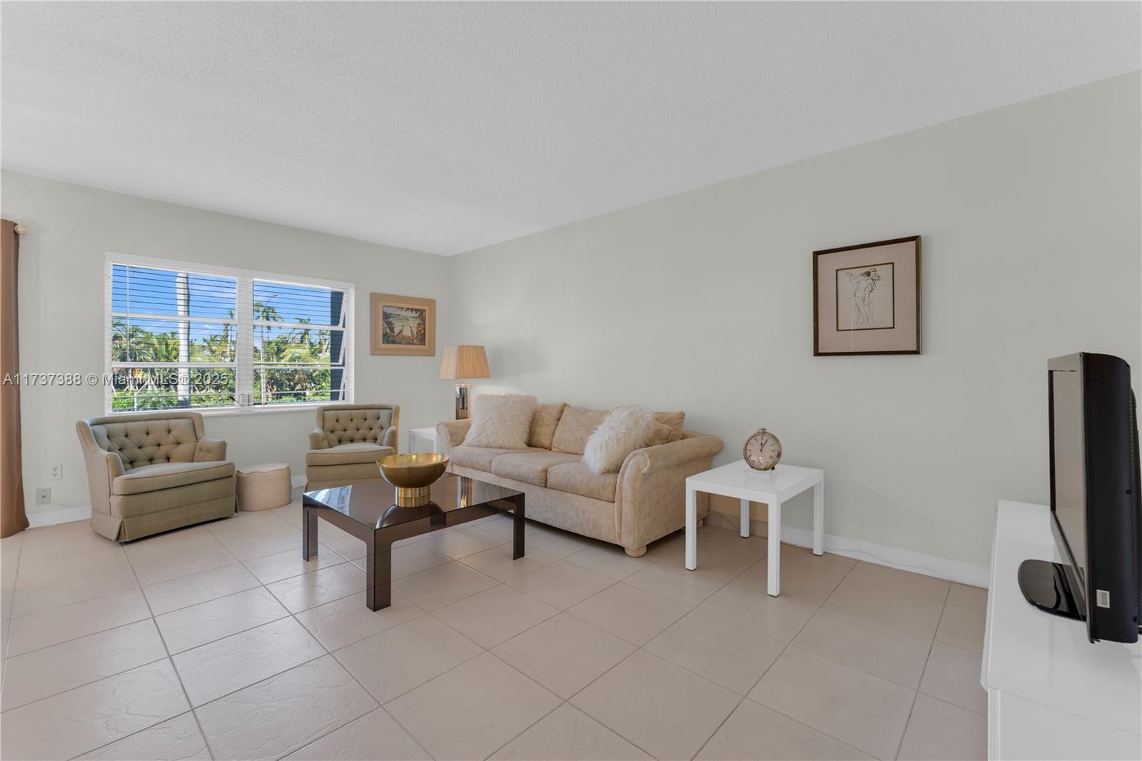 200 Diplomat Parkway, Unit 229 Hallandale Beach, FL 33009 - Photo 14 of 30 a living room with furniture and a flat screen tv