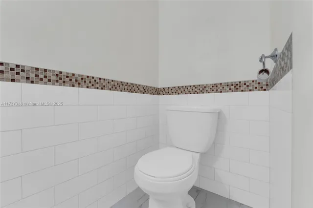 a bathroom with a toilet and a shower curtain