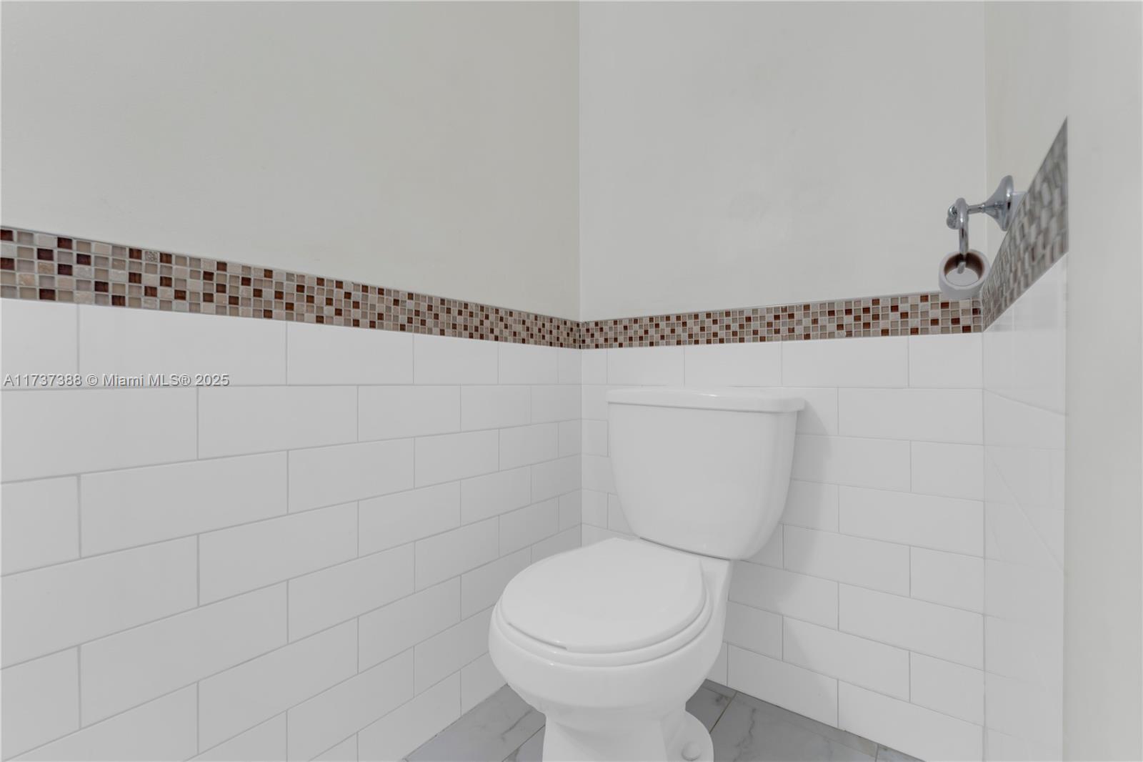 200 Diplomat Parkway, Unit 229 Hallandale Beach, FL 33009 - Photo 16 of 30 a bathroom with a toilet and a shower curtain