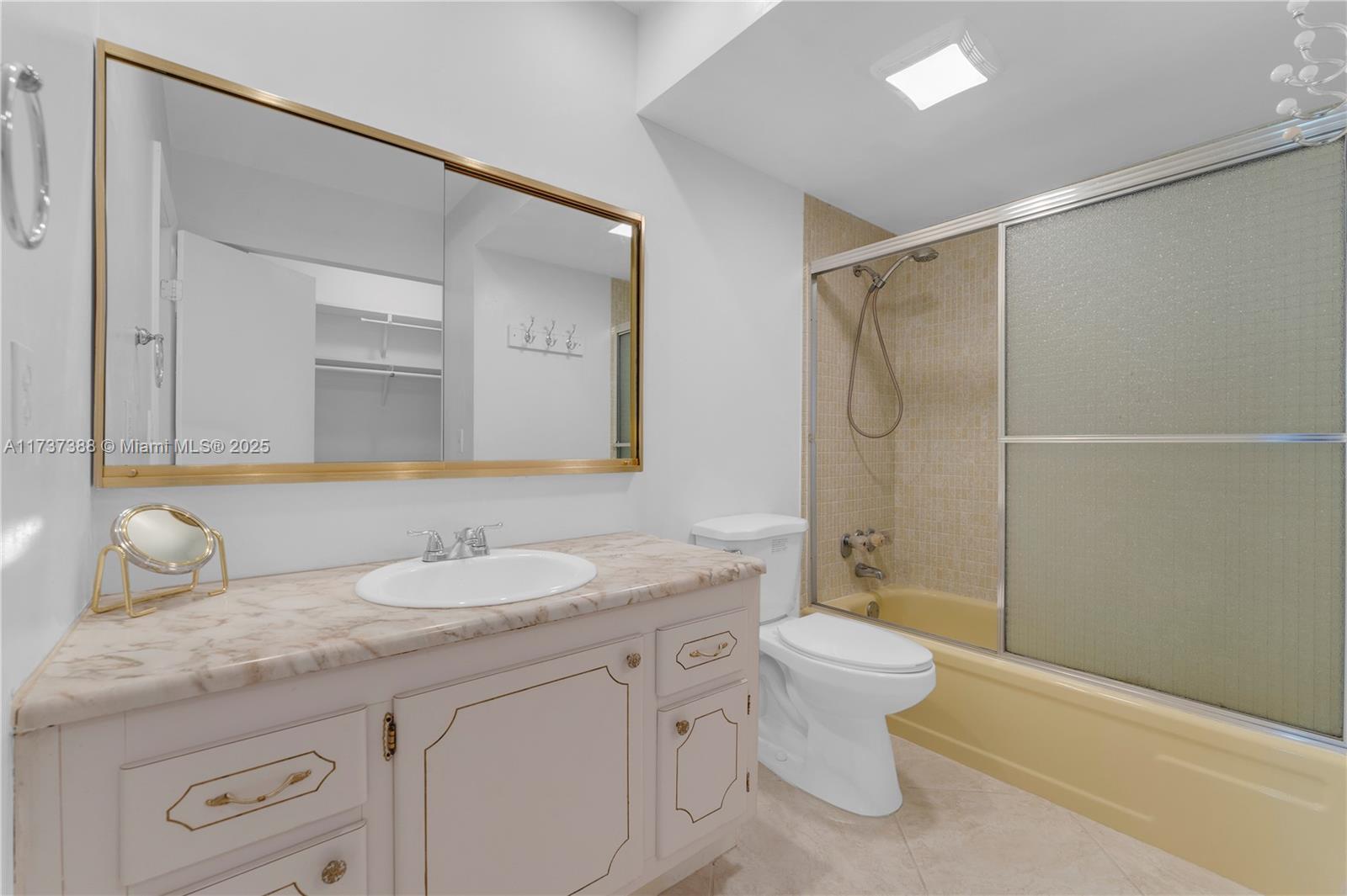 200 Diplomat Parkway, Unit 229 Hallandale Beach, FL 33009 - Photo 21 of 30 a bathroom with a granite countertop sink a toilet and a mirror