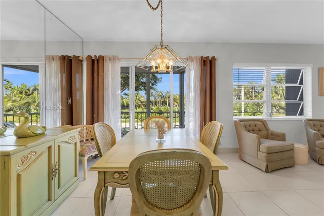 a dining room with furniture a chandelier and window