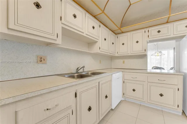 a kitchen with white cabinets and white appliances