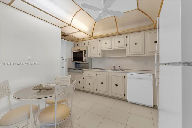 a kitchen with stainless steel appliances white cabinets a stove a sink and a refrigerator