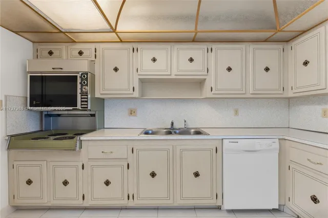 a kitchen with white cabinets and appliances