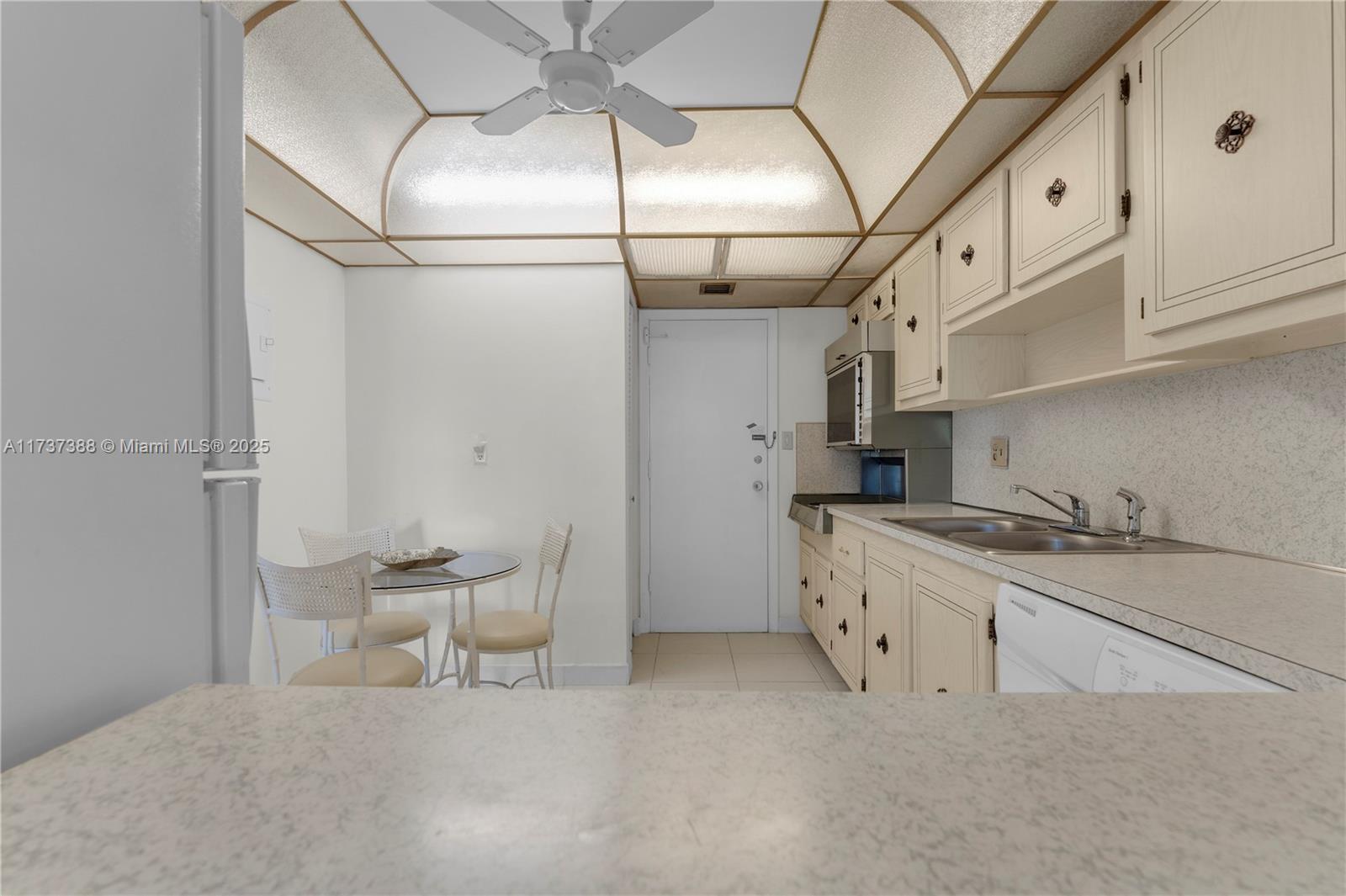 200 Diplomat Parkway, Unit 229 Hallandale Beach, FL 33009 - Photo 10 of 30 a kitchen with stainless steel appliances granite countertop a sink and cabinets
