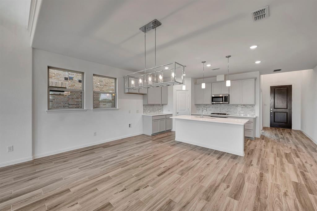 3704 Water Lily Way Prosper, TX 75078 - Photo 14 of 40 a large kitchen with kitchen island a sink stainless steel appliances and cabinets