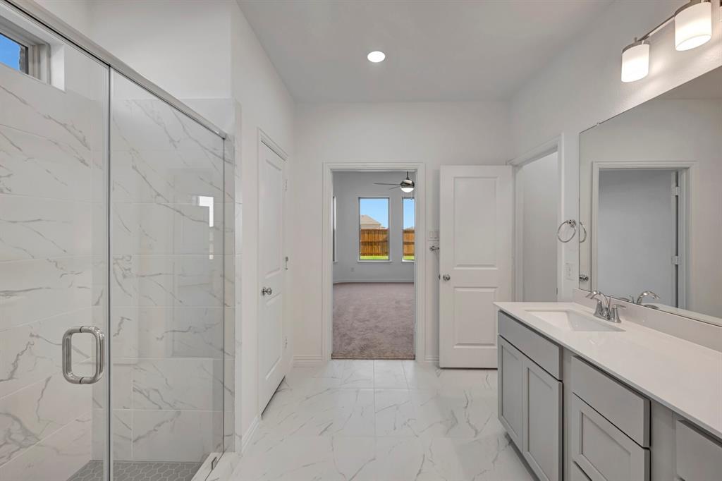 3704 Water Lily Way Prosper, TX 75078 - Photo 5 of 40 a bathroom with a granite countertop sink a mirror and a shower