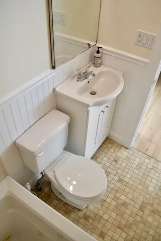a bathroom with a toilet sink and mirror