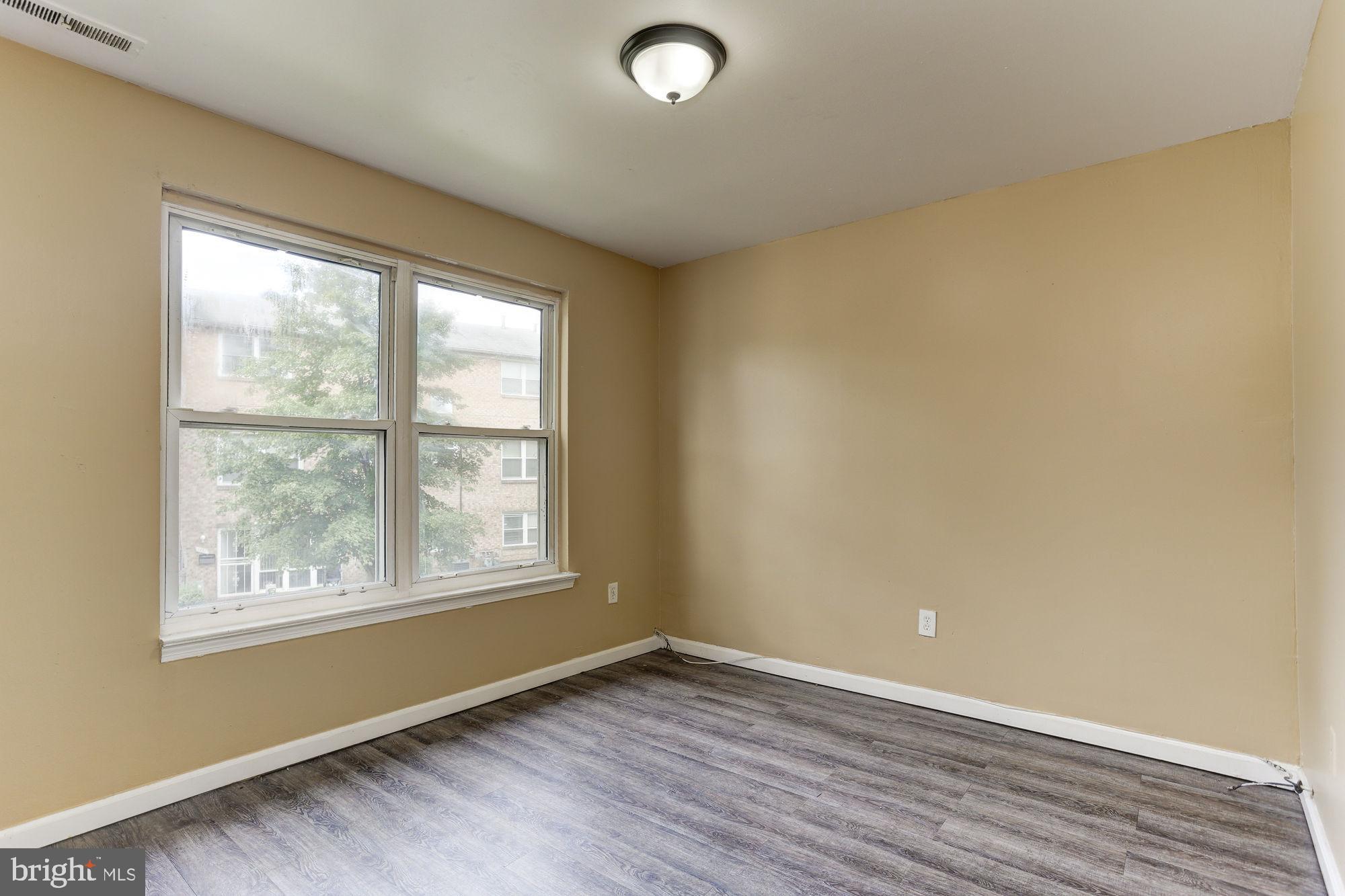 1925 Addison Road South District Heights, MD 20747 - Photo 4 of 9 an empty room with wooden floor and windows