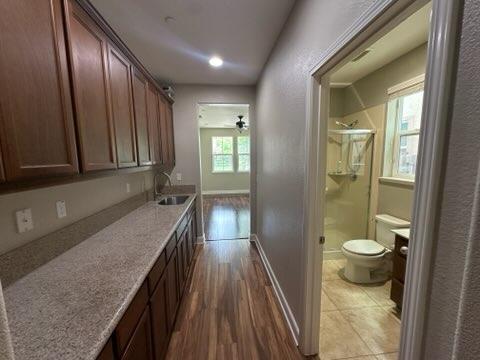 1749 Ettle Street Manteca, CA 95337 - Photo 10 of 12 Enjoy the added versatility of a spacious living area conveniently connected just off the kitchen. This private and inviting space features its own living room, bedroom, and full bathroom, along with a hallway equipped with a sink and built-in cabinets for added convenience and storage. Perfect for guests, extended family, multi-generational living, or a private retreat within the home.