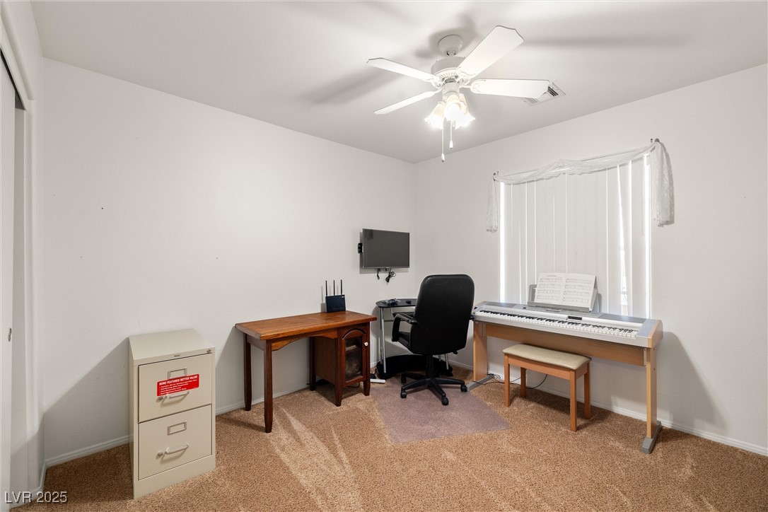 81 Diamond Bar Road Pahrump, NV 89048 - Photo 22 of 38 Bedroom with ceiling fan, light colored carpet, and baseboards