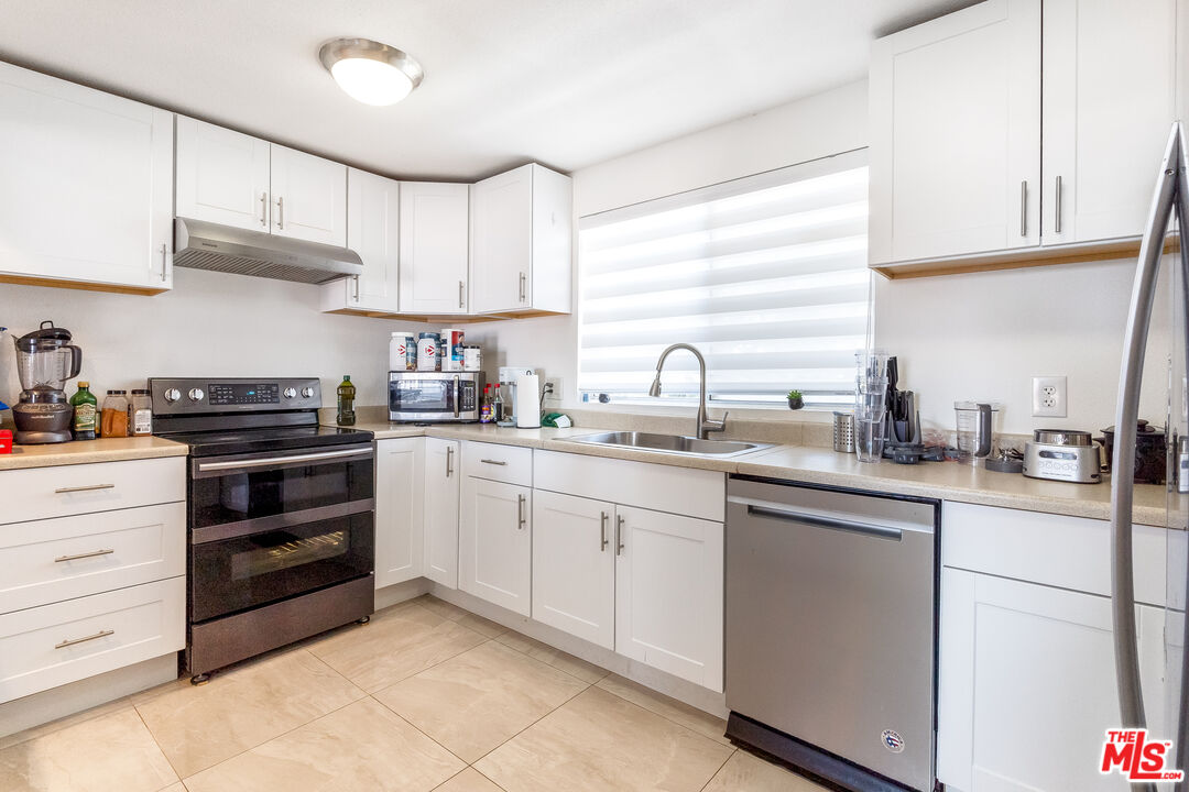 28390 Rey De Copas Lane Malibu, CA 90265 - Photo 3 of 18 a kitchen with cabinets appliances a sink and a window