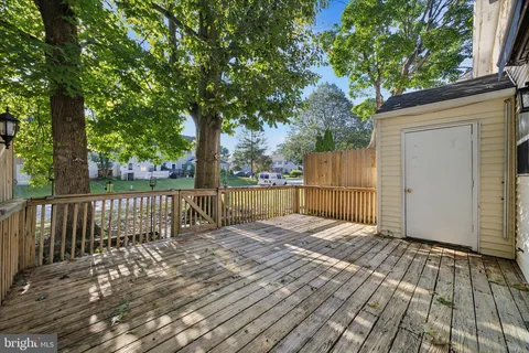 a view of backyard with wooden floor and fence