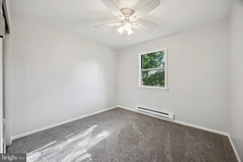an empty room with a window and a fan