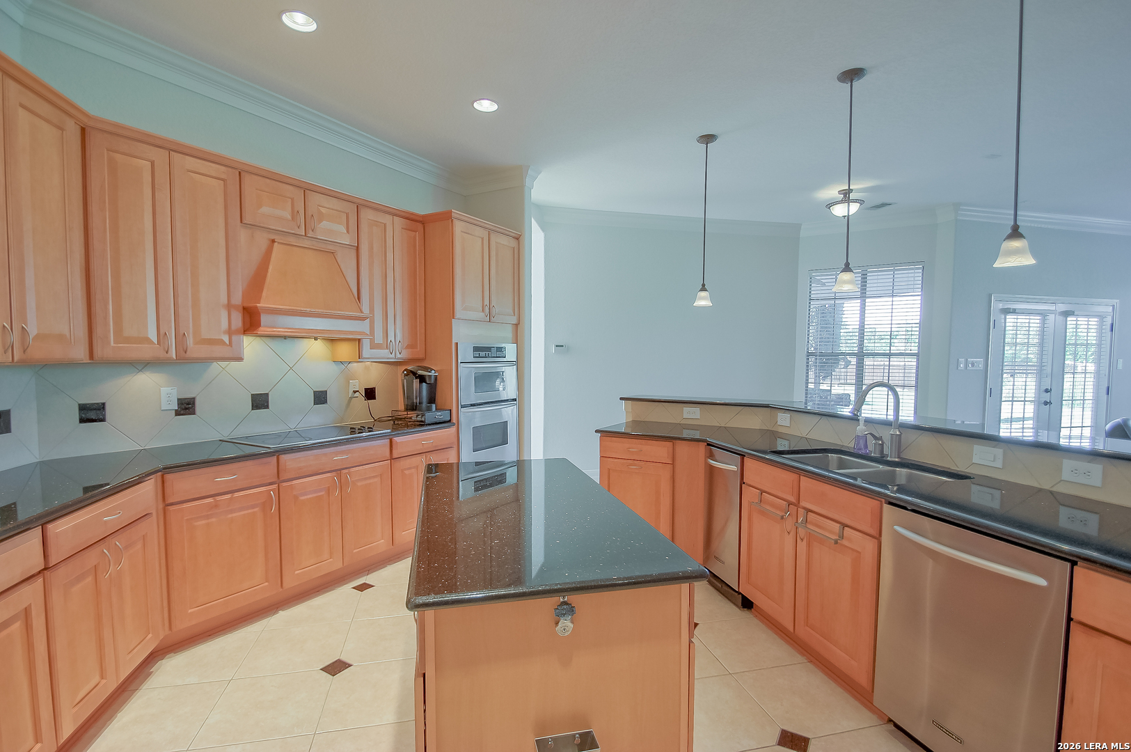 30901 Wood Bine Way Fair Oaks Ranch, TX 78015 - Photo 16 of 23 a kitchen with kitchen island granite countertop a sink window and cabinets
