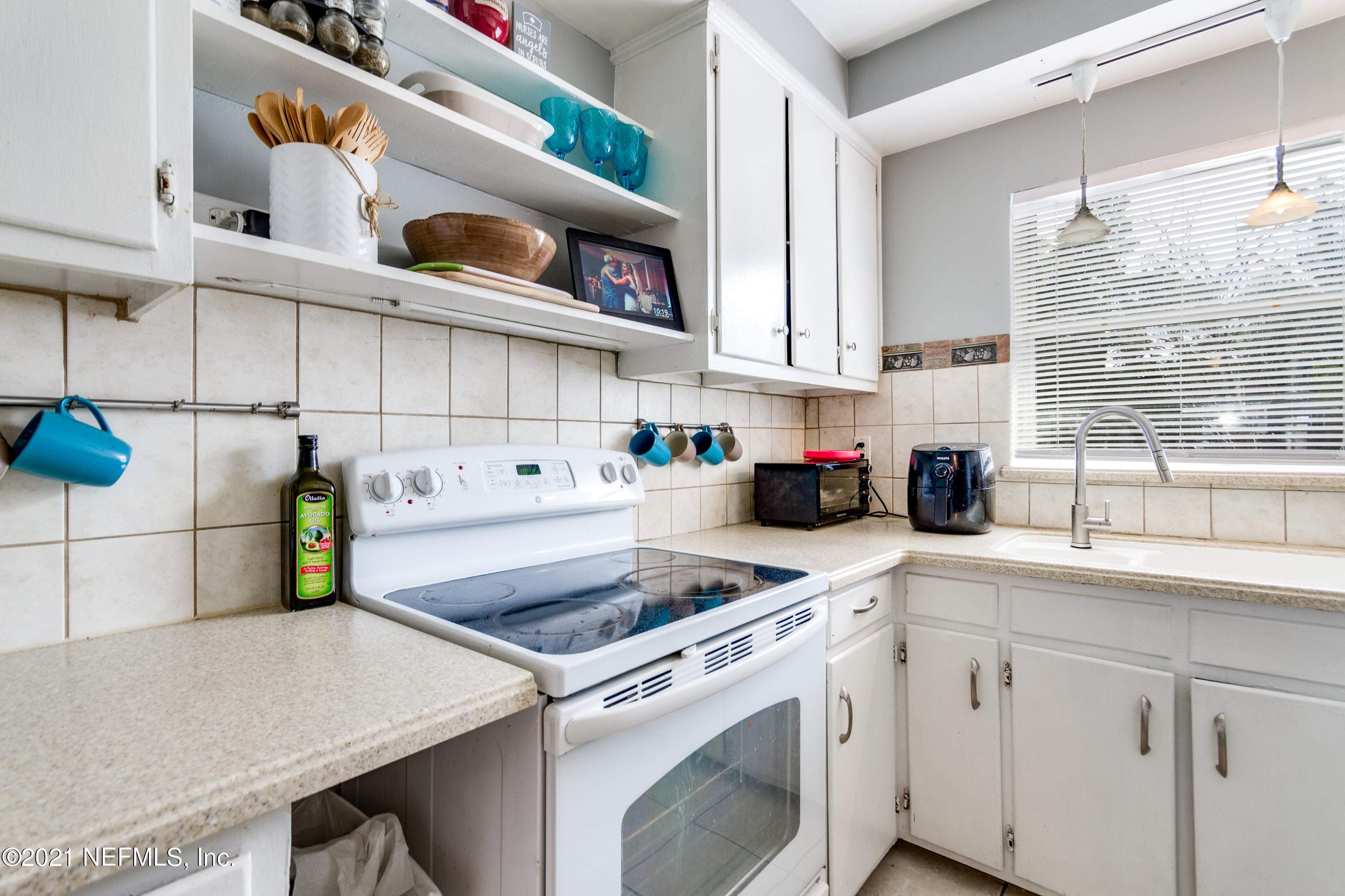 6044 Duke Road Jacksonville, FL 32217 - Photo 11 of 24 a kitchen with a sink a stove and cabinets