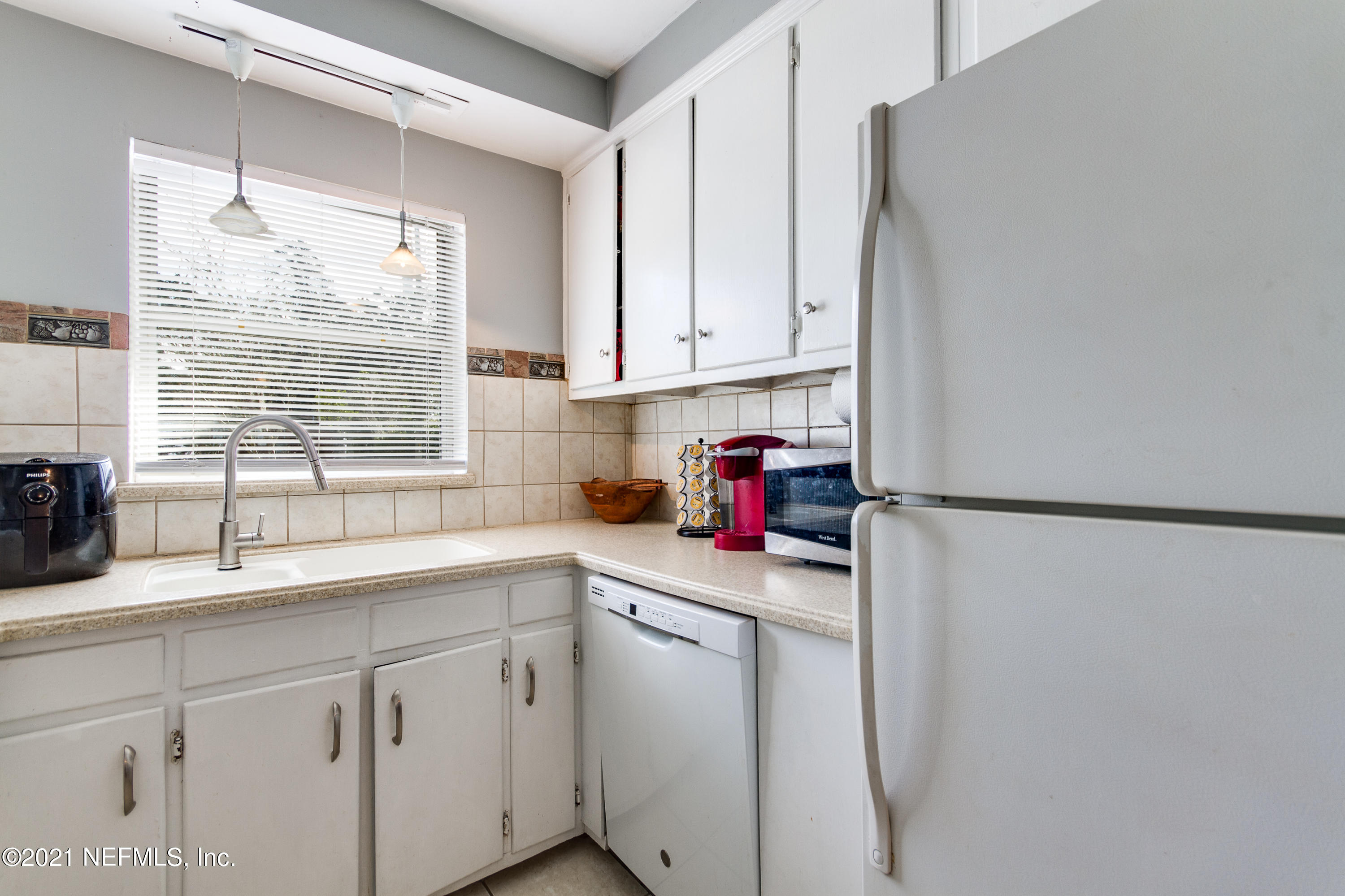 6044 Duke Road Jacksonville, FL 32217 - Photo 12 of 24 a kitchen with a sink a refrigerator and window