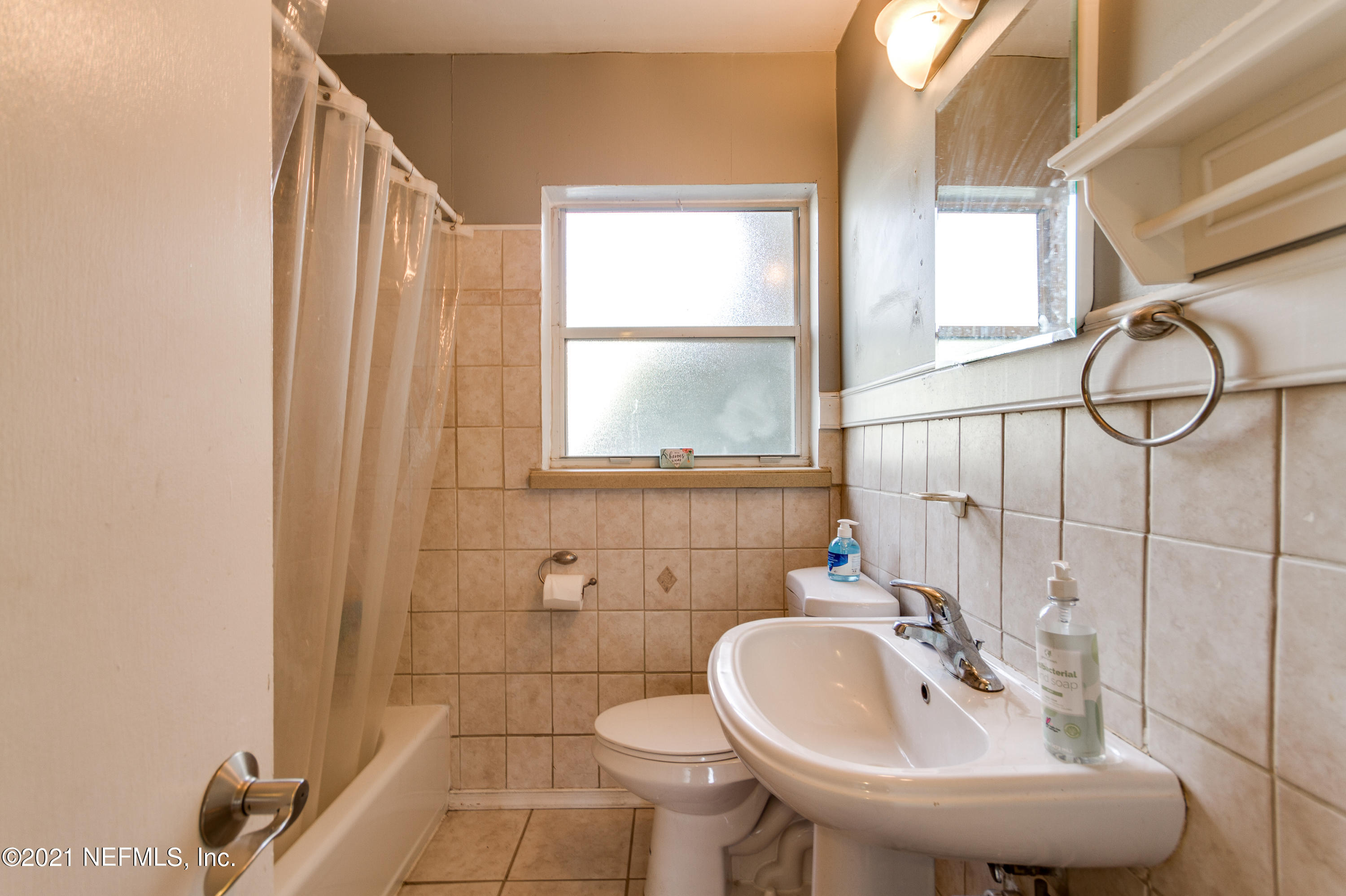 6044 Duke Road Jacksonville, FL 32217 - Photo 18 of 24 a bathroom with a sink a toilet and a mirror