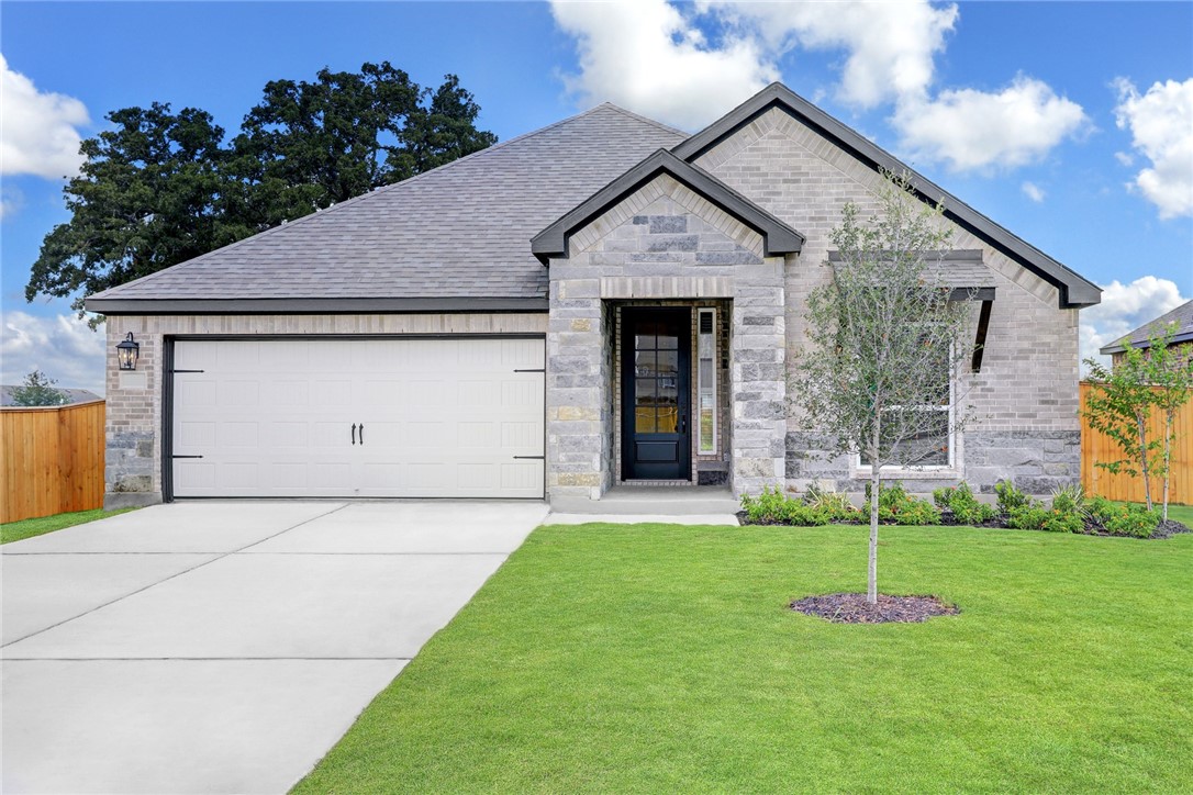 a front view of a house with a yard and a garage