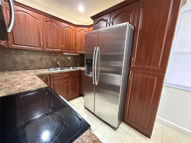 a kitchen with granite countertop a refrigerator and a sink