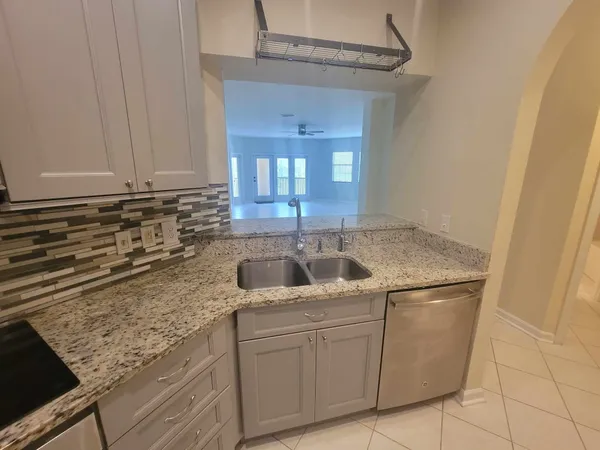 a kitchen with granite countertop a sink and a stove