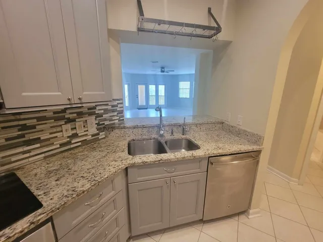 a kitchen with granite countertop a sink and a stove