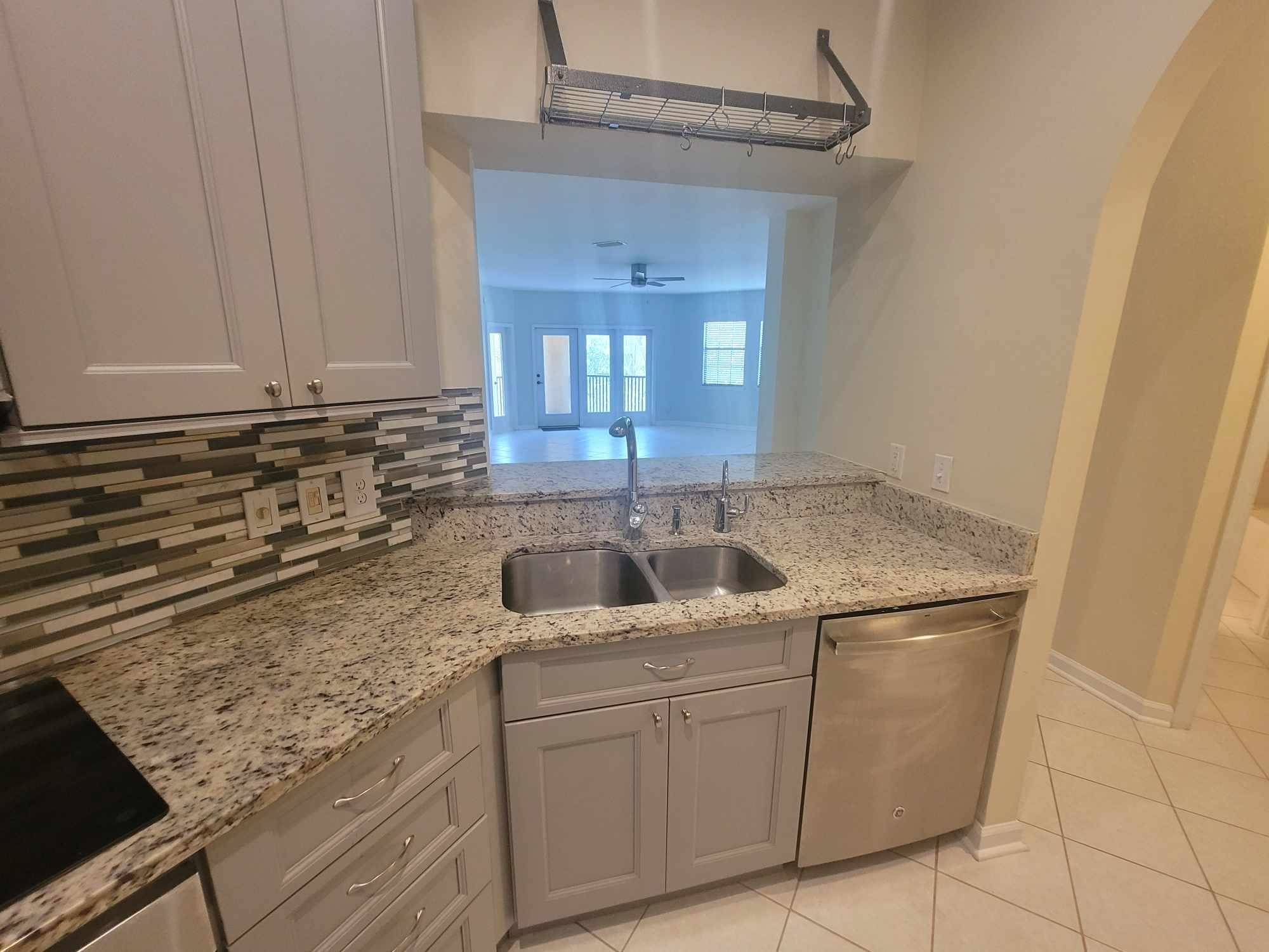 2431 Vista Cove Road St. Augustine, FL 32084 - Photo 5 of 33 a kitchen with granite countertop a sink and a stove