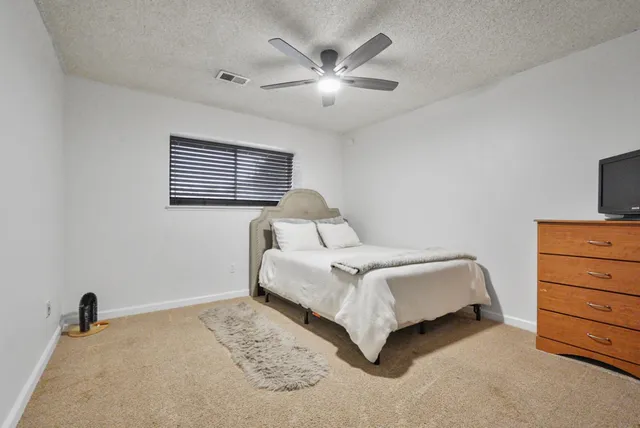 a bedroom with a bed and a ceiling fan