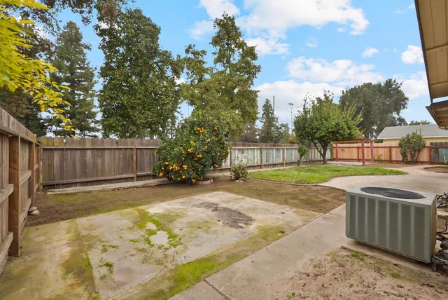 a view of yard with swimming pool and wooden fence