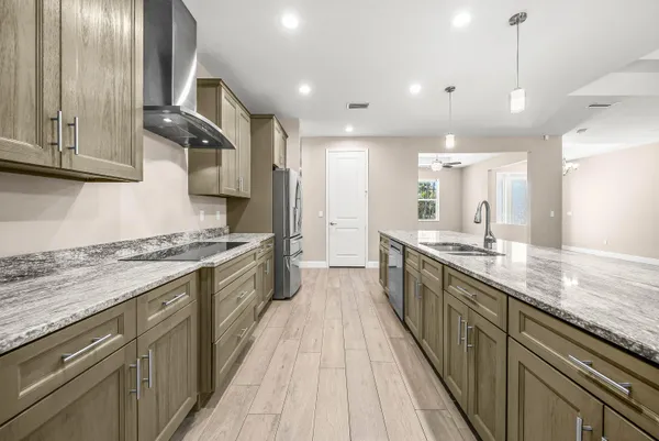 a large kitchen with stainless steel appliances granite countertop a lot of counter space and wooden floor