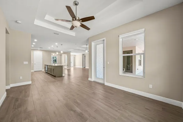 a view of a livingroom with a ceiling fan & wooden floor