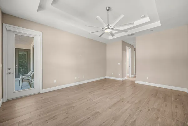 a view of an empty room with window and wooden floor