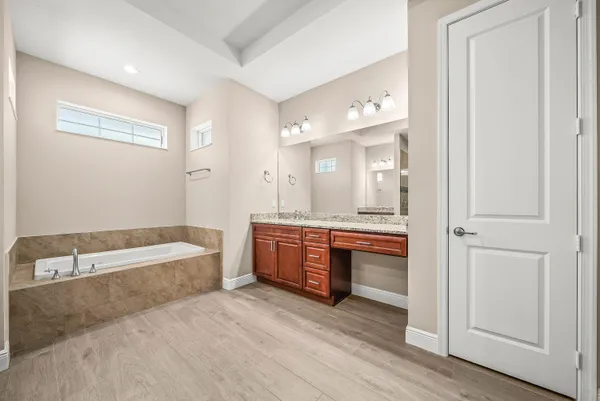 a bathroom with a tub a sink and a large mirror