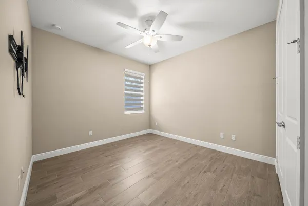 an empty room with windows and fan
