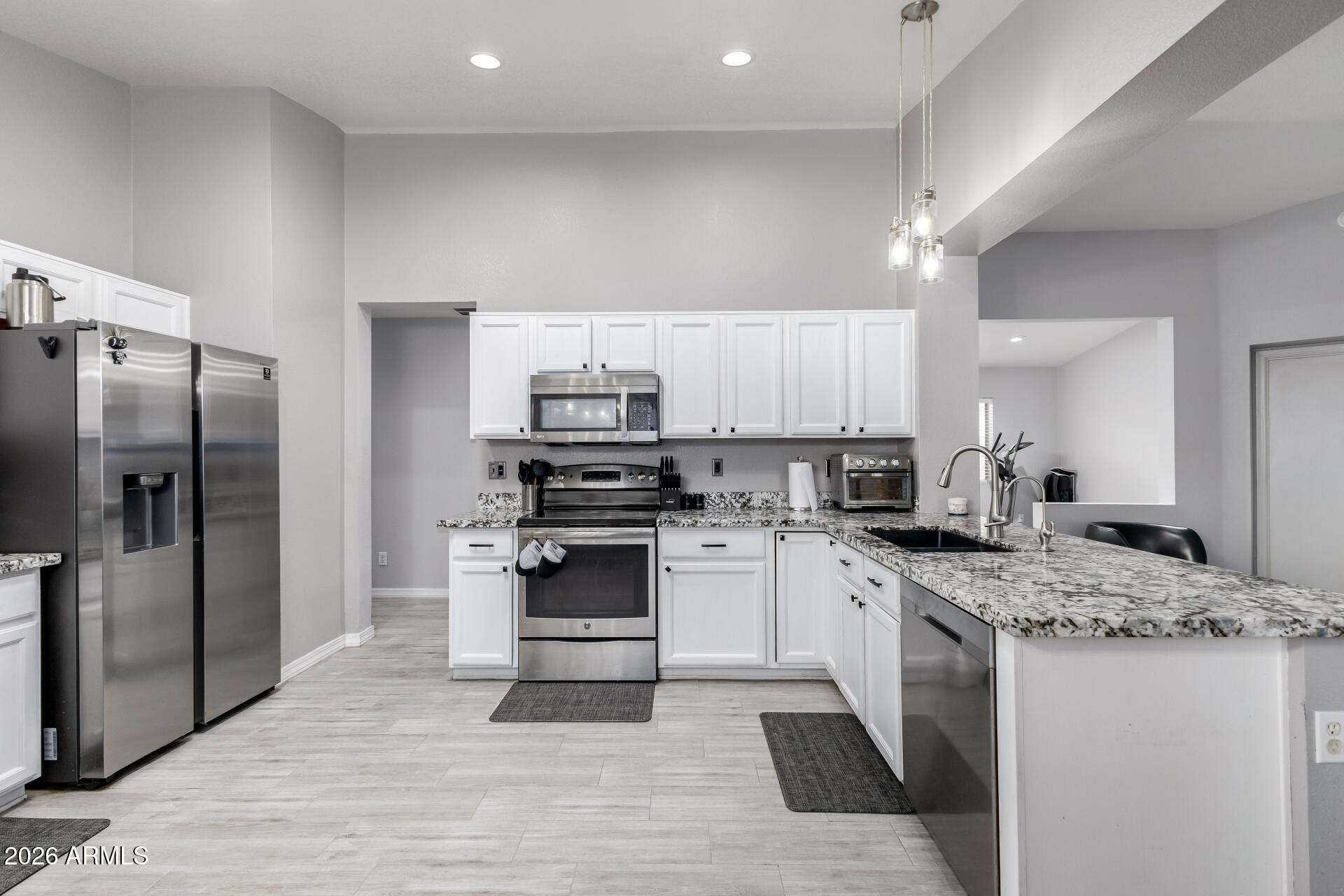 3407 East Escuda Road Phoenix, AZ 85050 - Photo 12 of 32 a kitchen with stainless steel appliances granite countertop a sink stove refrigerator and cabinets