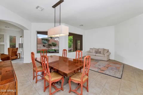 a dining room with furniture a chandelier and wooden floor