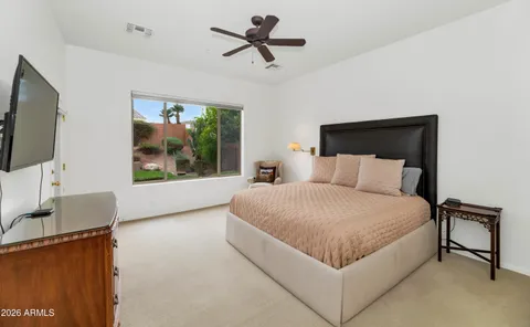 a bedroom with a large bed and a flat screen tv