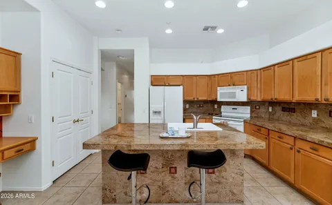 a view of kitchen with granite countertop lots of counter top space and stainless steel appliances