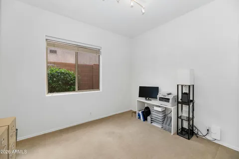 a view of a workspace with furniture and a window