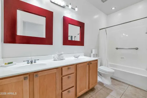 a bathroom with double vanity sink a mirror a toilet and a bathtub