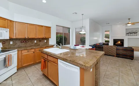 a kitchen with stainless steel appliances granite countertop a sink a stove and a refrigerator