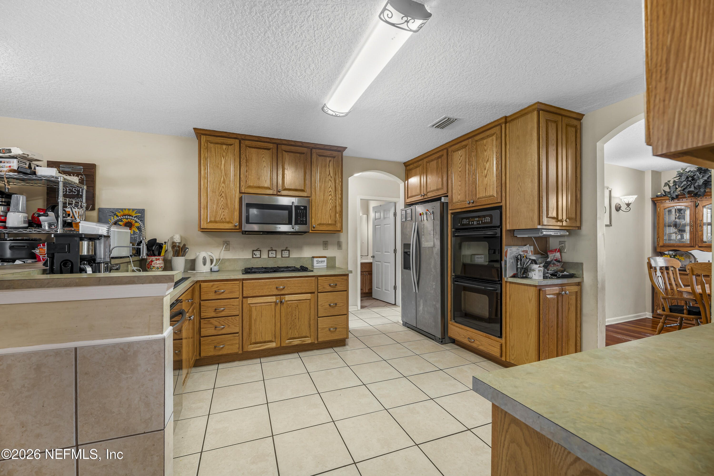 1725 Davidson Farm Road Jacksonville, FL 32218 - Photo 27 of 53 a kitchen with stainless steel appliances granite countertop a refrigerator and a stove top oven