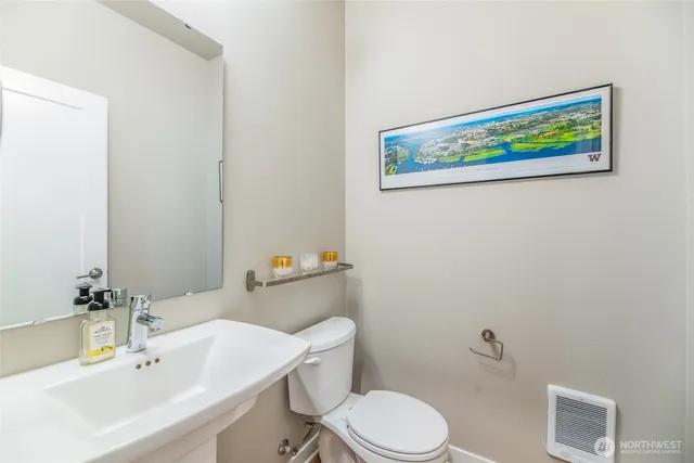 a bathroom with a sink mirror and toilet