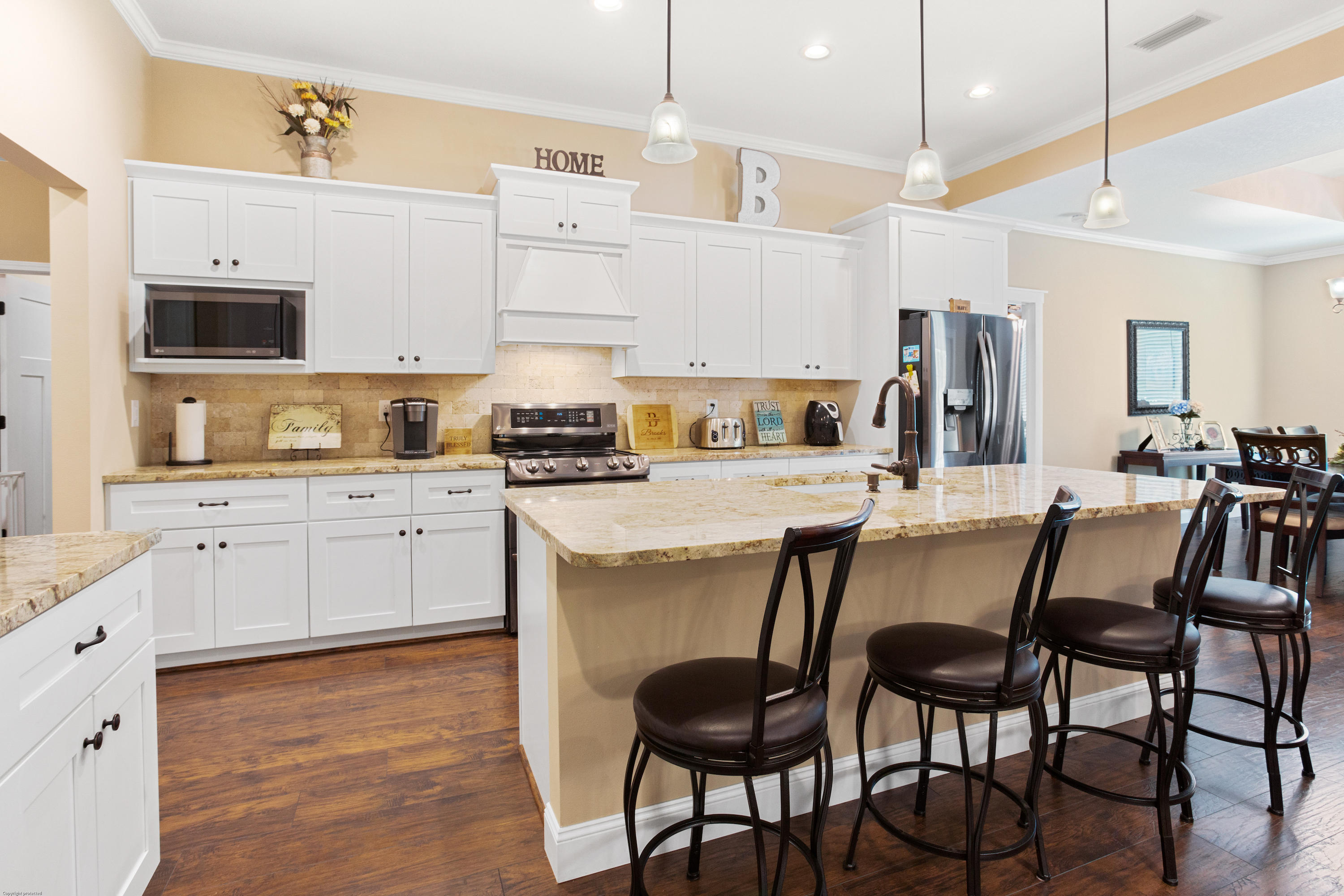 5887 Oak Hill Road Crestview, FL 32536 - Photo 7 of 44 a kitchen with stainless steel appliances kitchen island granite countertop a table chairs sink and cabinets