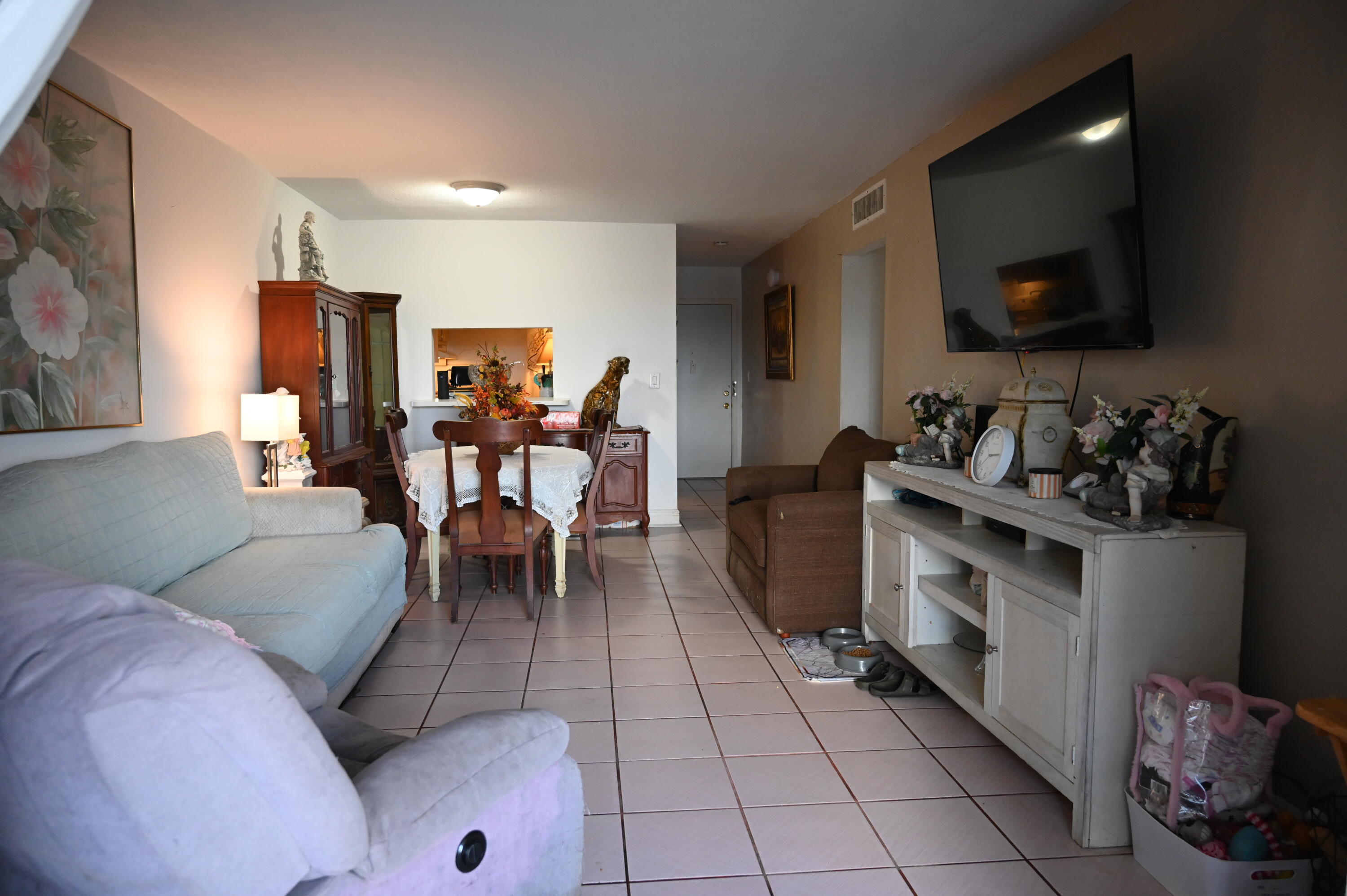 6215 West 20th Avenue, Unit 415 Hialeah, FL 33012 - Photo 14 of 39 a living room with furniture and a flat screen tv