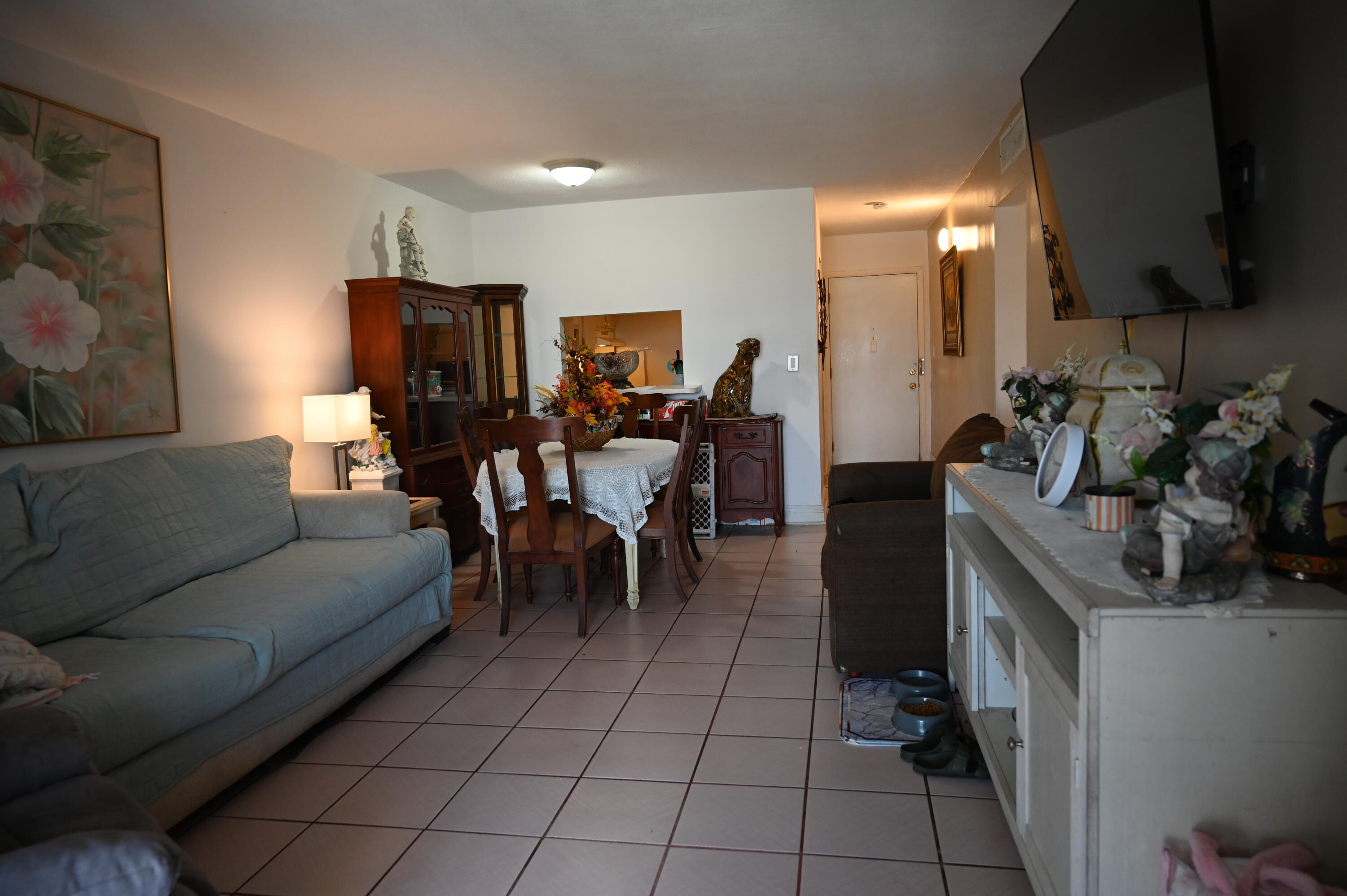 6215 West 20th Avenue, Unit 415 Hialeah, FL 33012 - Photo 15 of 39 a living room with furniture a flat screen tv and kitchen view