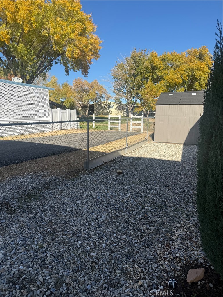 13393 Mariposa Road, Unit 97 Victorville, CA 92395 - Photo 26 of 32 a view of yard with large tree and wooden fence