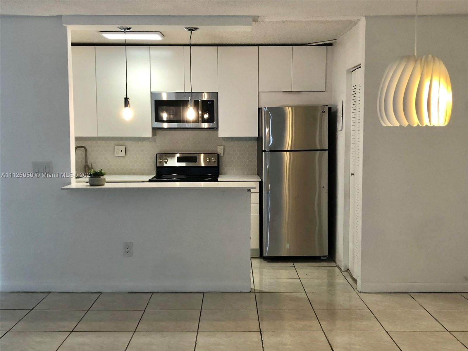 a kitchen with stainless steel appliances a refrigerator a stove a microwave and cabinets