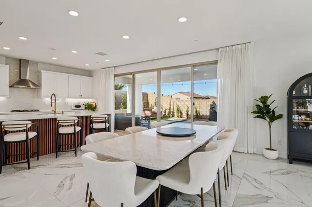 a kitchen with a dining table chairs and white cabinets