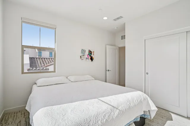 a view of a white house with a big yard and potted plants